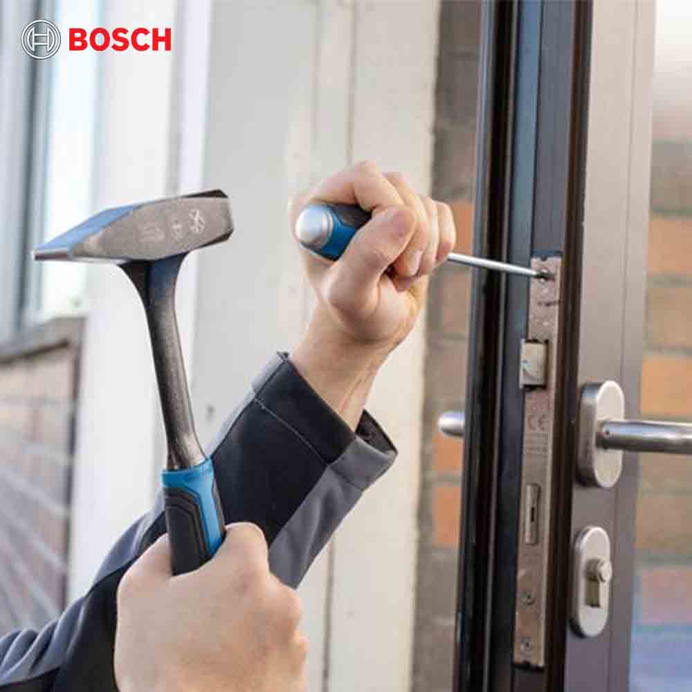 Person using a screwdriver to open a door with Bosch logo in the corner.