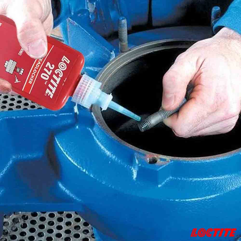 Person applying Loctite 270 thread locker to a bolt with a blue tool