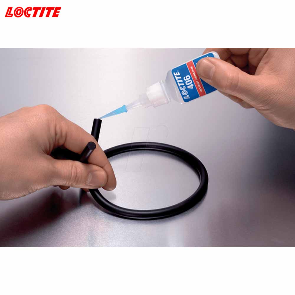 Person applying Loctite 406 adhesive to a black rubber ring on a white background.