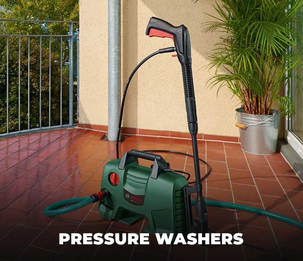 Pressure washer with hose on a tiled patio with plants and a fence in the background.
